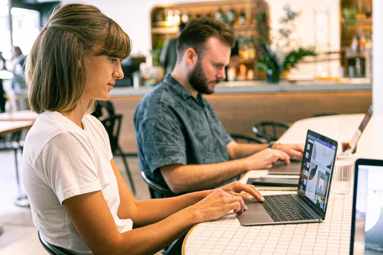 Male and female recruitment website designers sitting at laptops