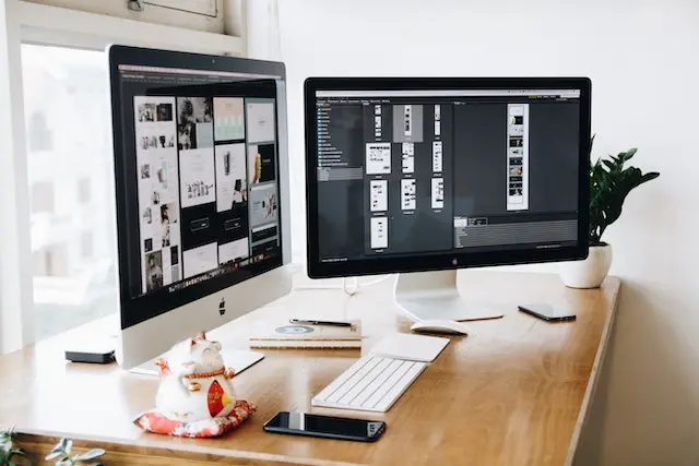 two desktop screens on desk